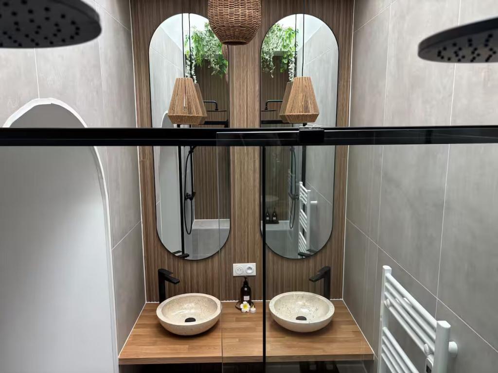 Grande salle de bain avec mur végétal et double douche italienne – Suite Banjar